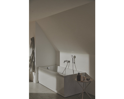 Koupelna s vanou, baterií a sprchovou hlavicí pod šikmou střechou
