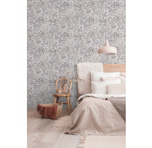 Ložnice s květinovou tapetou, postelí, židlí a košem