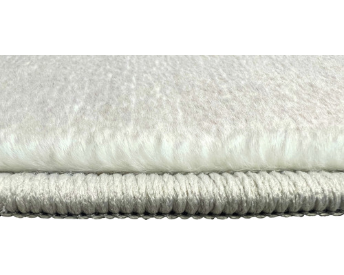 Detailní pohled na bílý koberec s vysokým vlasem