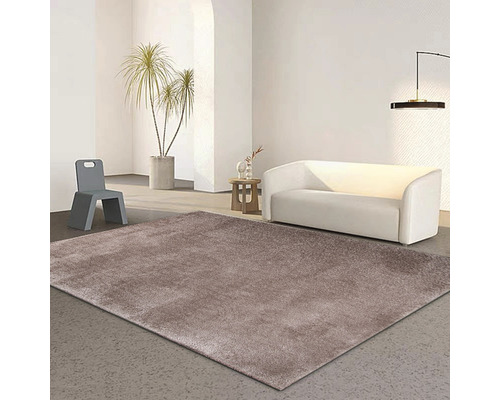 Obývací pokoj s hnědým kobercem, bílou pohovkou a šedou židlí.