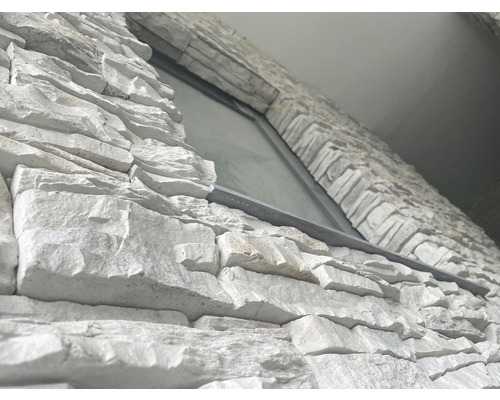 Detailní záběr obkladu stěny s kamenným vzhledem kolem okna