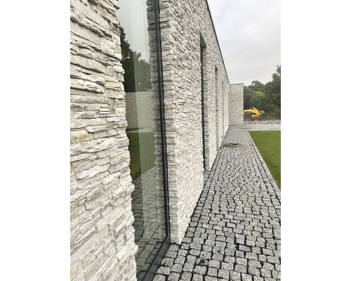 Venkovní fotografie budovy se zdivem a dlažebními kostkami