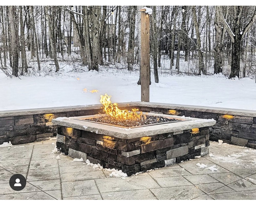 Čtvercové kamenné ohniště s plameny ve venkovním prostředí