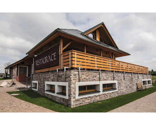 Vnější pohled na restauraci s kamennými zdmi a dřevěnými prvky.