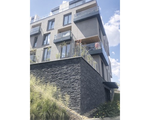 Vícepodlažní budova s fasádou z přírodního kamene a balkony