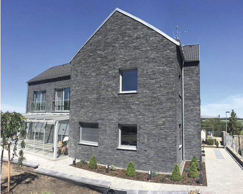 Fasáda domu s kamenným obkladem a okny