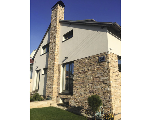 Fasáda domu s obkladovými kameny a komínem