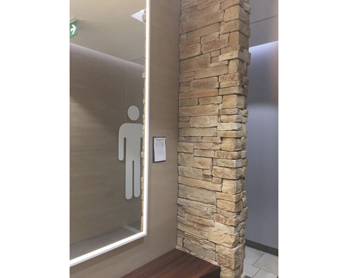 Pánská toaleta s kamennou zdí a zrcadlem