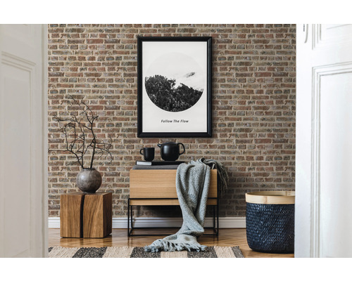 Dekorativní obývací pokoj s tapetou s motivem cihel, dřevěnou komodou a odpovídajícími doplňky.