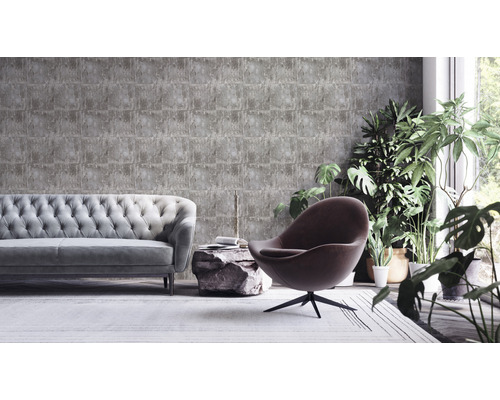 Obývací pokoj s šedou tapetou v kamenném vzhledu, pohovkou, křeslem a pokojovými rostlinami