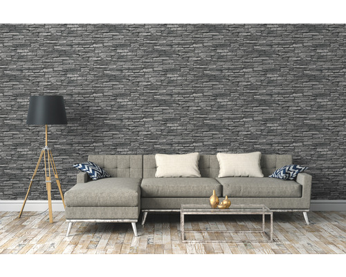 Obývací pokoj s šedou tapetou se vzhledem kamene, pohovkou, stojací lampou a konferenčním stolkem.