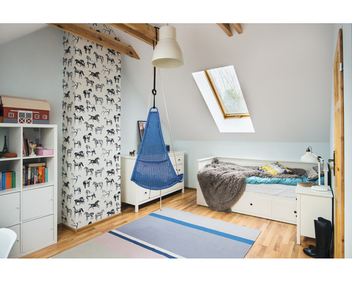 Světlá místnost v podkroví se závěsnou lampou, závěsným křeslem a dětskou postelí