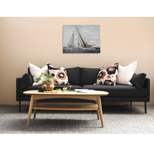 Obývací pokoj s pohovkou, dřevěným stolem a obrazem plachetnic