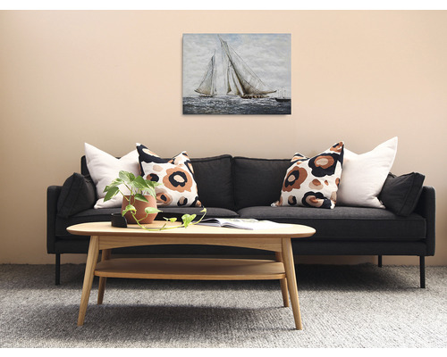 Obývací pokoj s pohovkou, dřevěným stolem a obrazem plachetnic