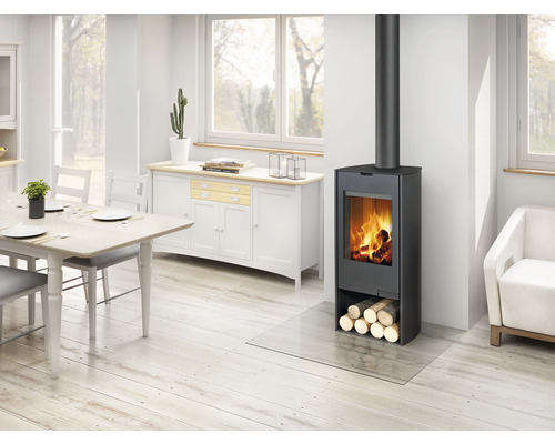 Obývací pokoj s kamny na dřevo, poleny a skleněnou deskou jako podložkou