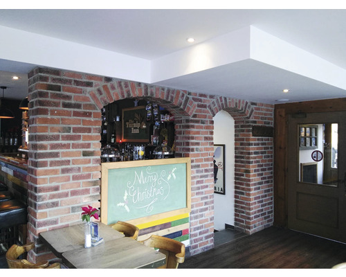 Interiér restaurace s cihlovým zdivem a tabulí