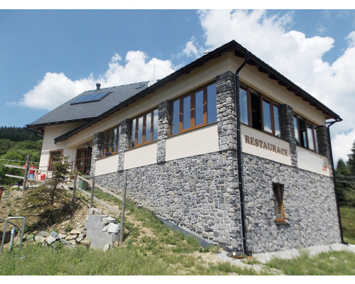 Venkovní pohled na restauraci s kamennou fasádou, okny a střechou