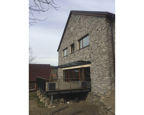 Fasáda domu s kamenným obkladem a terasou