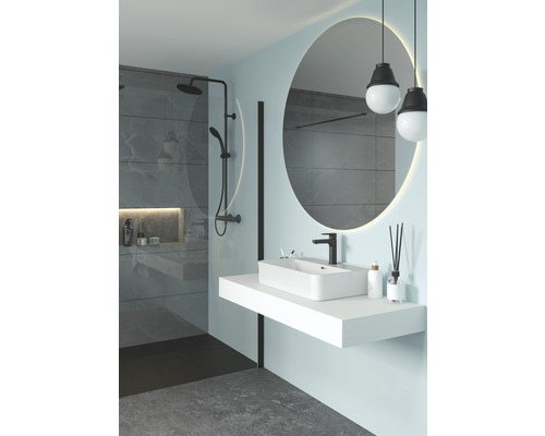 Moderní koupelna se sprchou, umyvadlem a kulatým zrcadlem