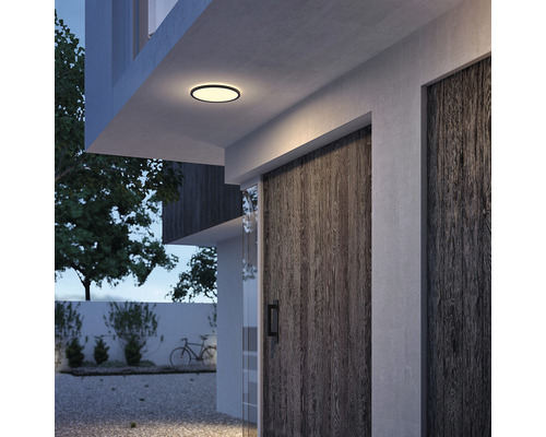 Moderní exteriér domu s kulatým stropním svítidlem.