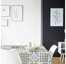 Jídelní stůl s voskovým ubrusem se vzorem v světlé jídelně.