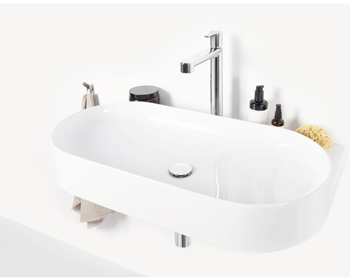 Keramické umyvadlo na desku s vodovodní baterií a kosmetickými produkty