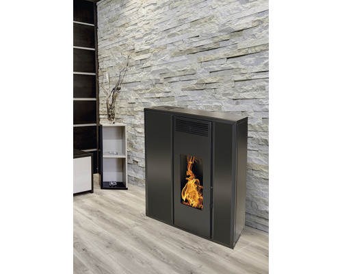 Černá peletová kamna v obývacím pokoji s kamennou zdí