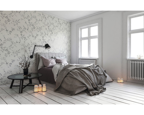 Světlá ložnice s postelí, nočním stolkem a ozdobnou tapetou