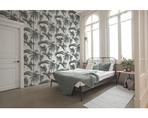 Ložnice s postelí a tapetou s motivem palem