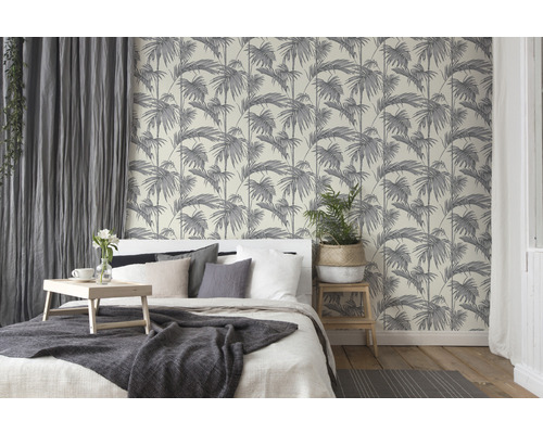 Ložnice s postelí a tapetou s motivem palem