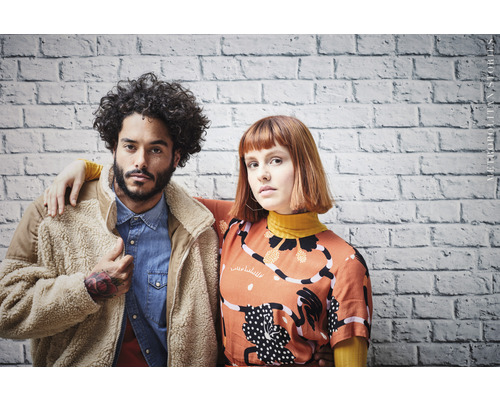 Portrét dvou lidí před cihlovou zdí