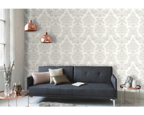 Obývací pokoj s šedou pohovkou a vzorovanou tapetou