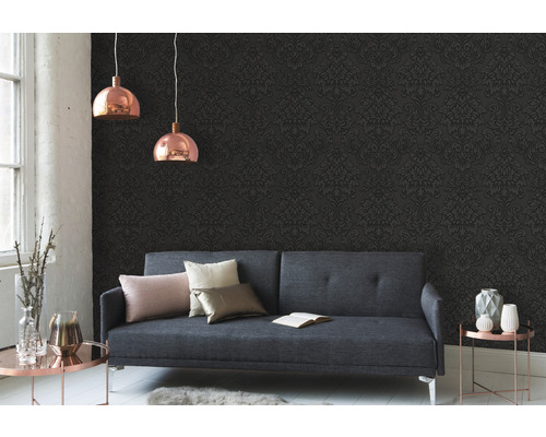 Obývací pokoj s šedou pohovkou, vzorovanou tapetou a dvěma závěsnými lampami