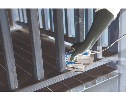 Osoba používá multifunkční brusku WORX k broušení dřevěného zábradlí.
