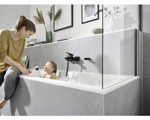 Moderní koupelna s vanou, sprchovou zástěnou, armaturou a obklady v šedých tónech