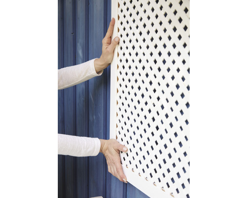 Osoba montuje bílou mřížovinu
