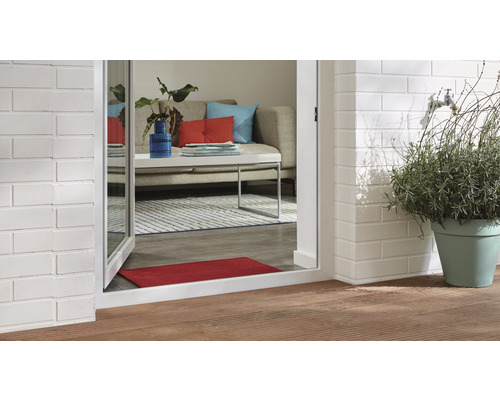 Pohled skrz otevřené terasové dveře do obývacího pokoje a na terasu s rostlinou