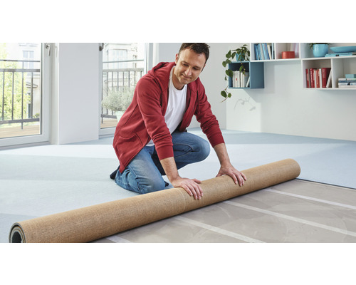 Muž rozkládá koberec na podlahu