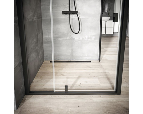 Walk-in sprcha s černým rámem, sprchová armatura a podlahový odtok v moderně navržené koupelně.