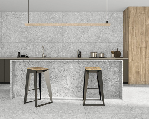 Moderní kuchyně s kuchyňským ostrovem, dvěma barovými stoličkami a šedými dlaždicemi