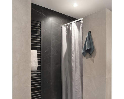 Koupelna s radiátorem, sprchovým závěsem a ručníkem