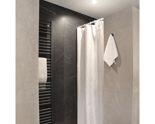 Moderní koupelna s radiátorem, sprchovým závěsem a ručníkem