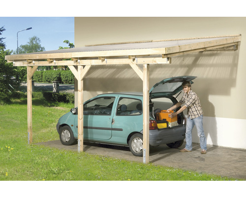 Dřevěný přístřešek pro auto s automobilem pod ním a osobou, která něco vyndává z kufru.