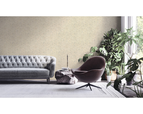 Obývací pokoj s pohovkou, křeslem a pokojovými rostlinami před vzorovanou tapetou.