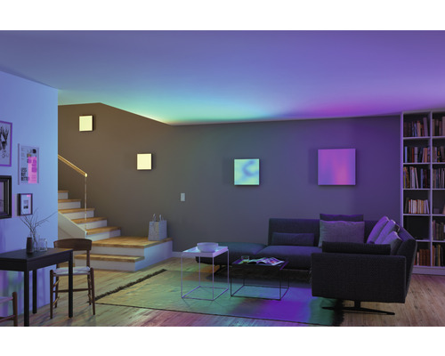 Moderní obývací pokoj s pohovkou, schodištěm a knihovnou