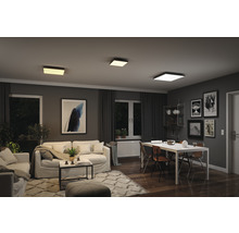 Obývací pokoj se stropními svítidly, pohovkou, stolem a dekorací