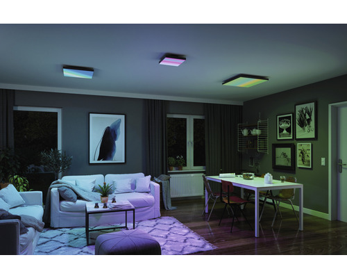 Obývací pokoj se třemi čtvercovými stropními svítidly, pohovkou, stolem a dekorací