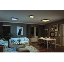 Obývací pokoj s pohovkami, jídelním stolem a čtvercovými stropními svítidly