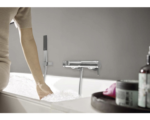 Scéna v koupelně s vanou, sprchovou soupravou a armaturou