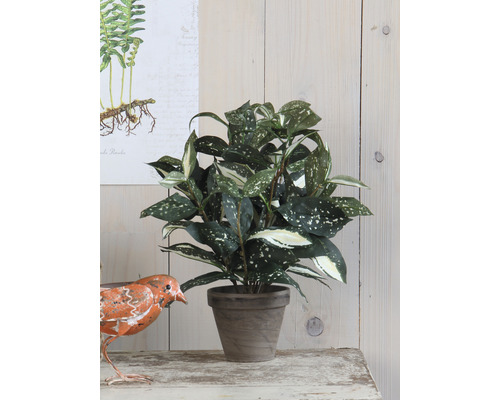 Umělá rostlina v květináči jako dekorace na stůl